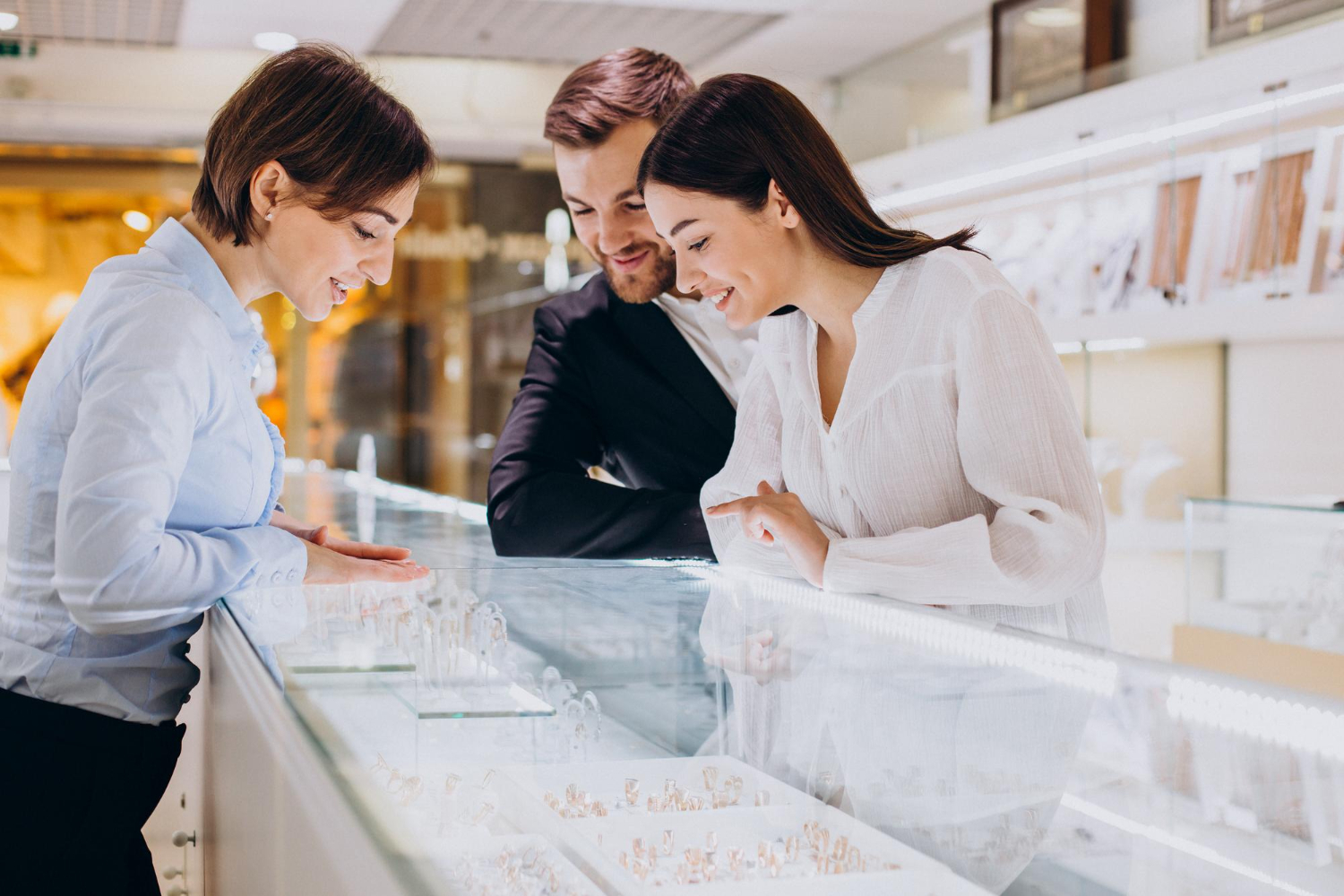 a couple in a jewelry store speaking to a salesperson